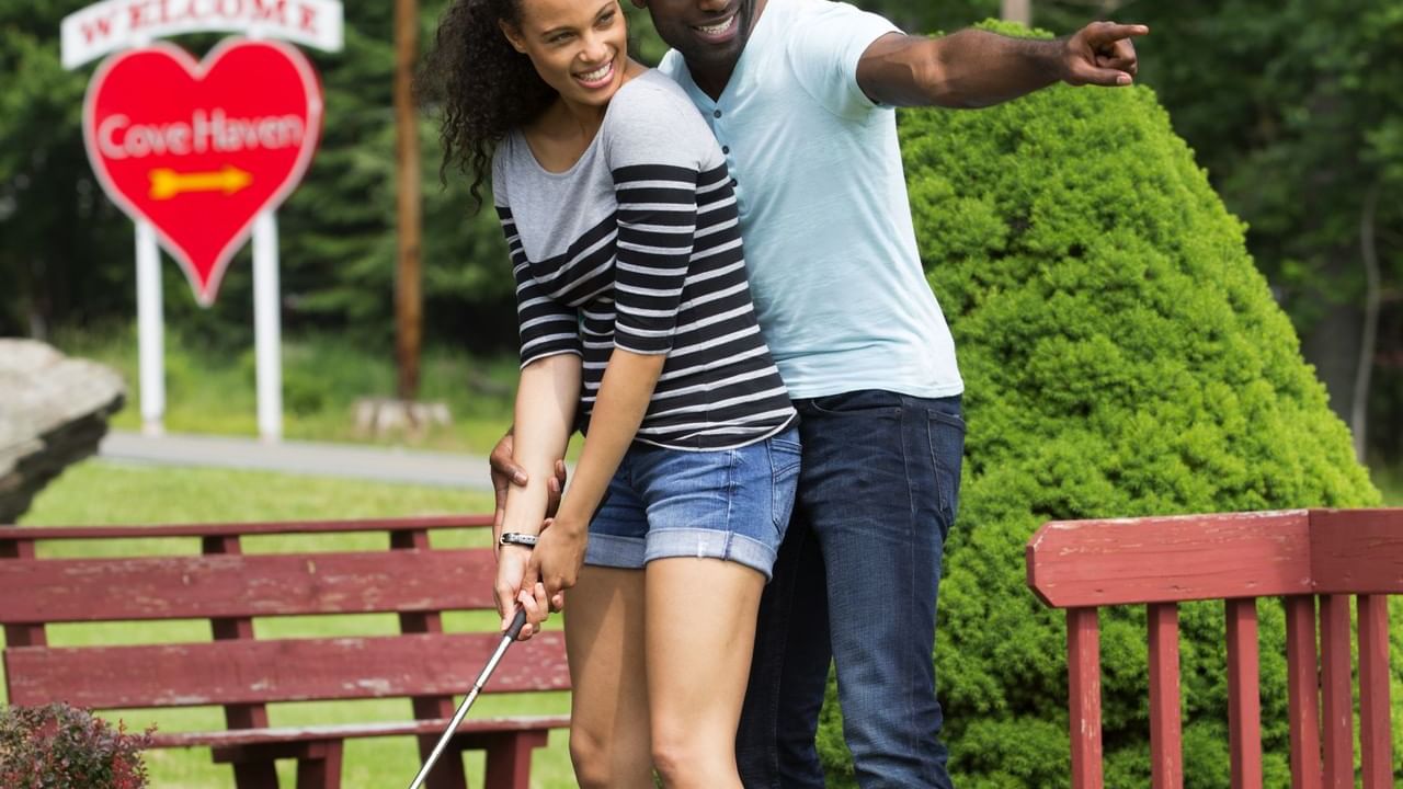 Couple playing Miniature golf in Cove Haven near Cove Pocono Resorts