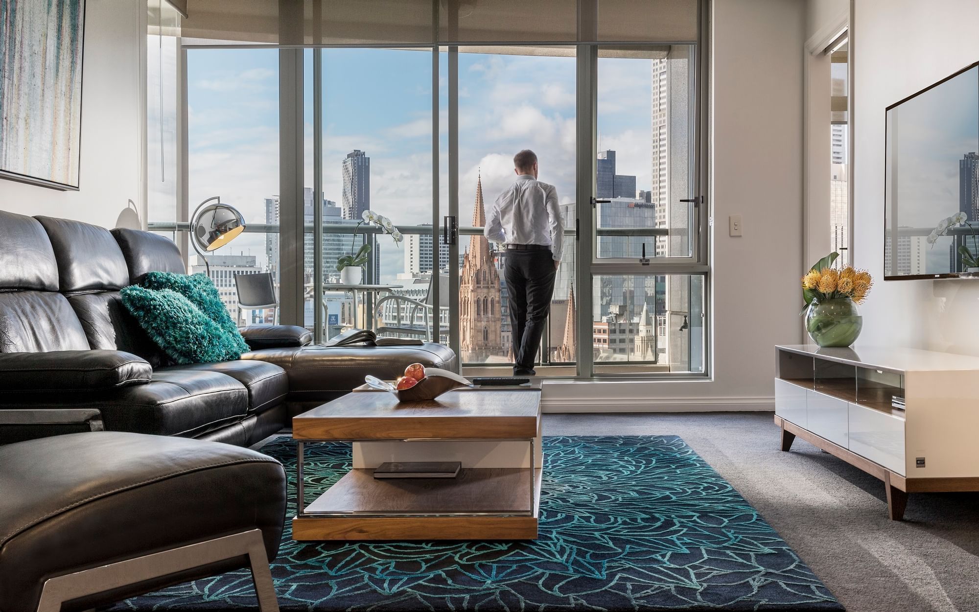 Man in the 3 Bedroom 2 Bathroom Premium Apartment balcony at Quay West Suites Melbourne