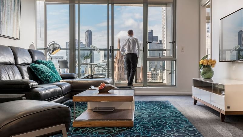 Man in the 3 Bedroom 2 Bathroom Premium Apartment balcony at Quay West Suites Melbourne