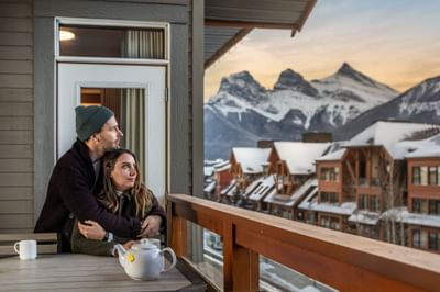 Couple embracing on the balcony of Two Bedroom Mountain View Suite at Blackstone Mountain Lodge