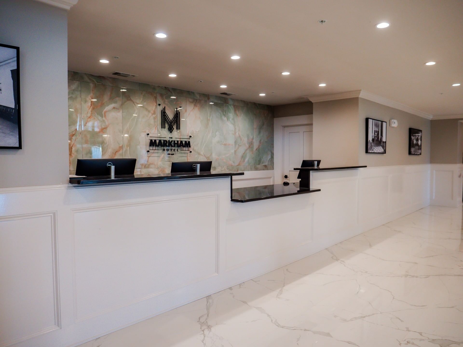 The Markham Hotel reception desk with white paneling and a green marble feature wall