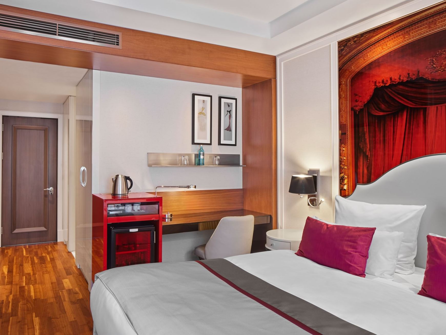 Großes Bett mit Arbeitsbereich in einem Deluxe Zimmer des Titanic Gendarmenmarkt Berlin.