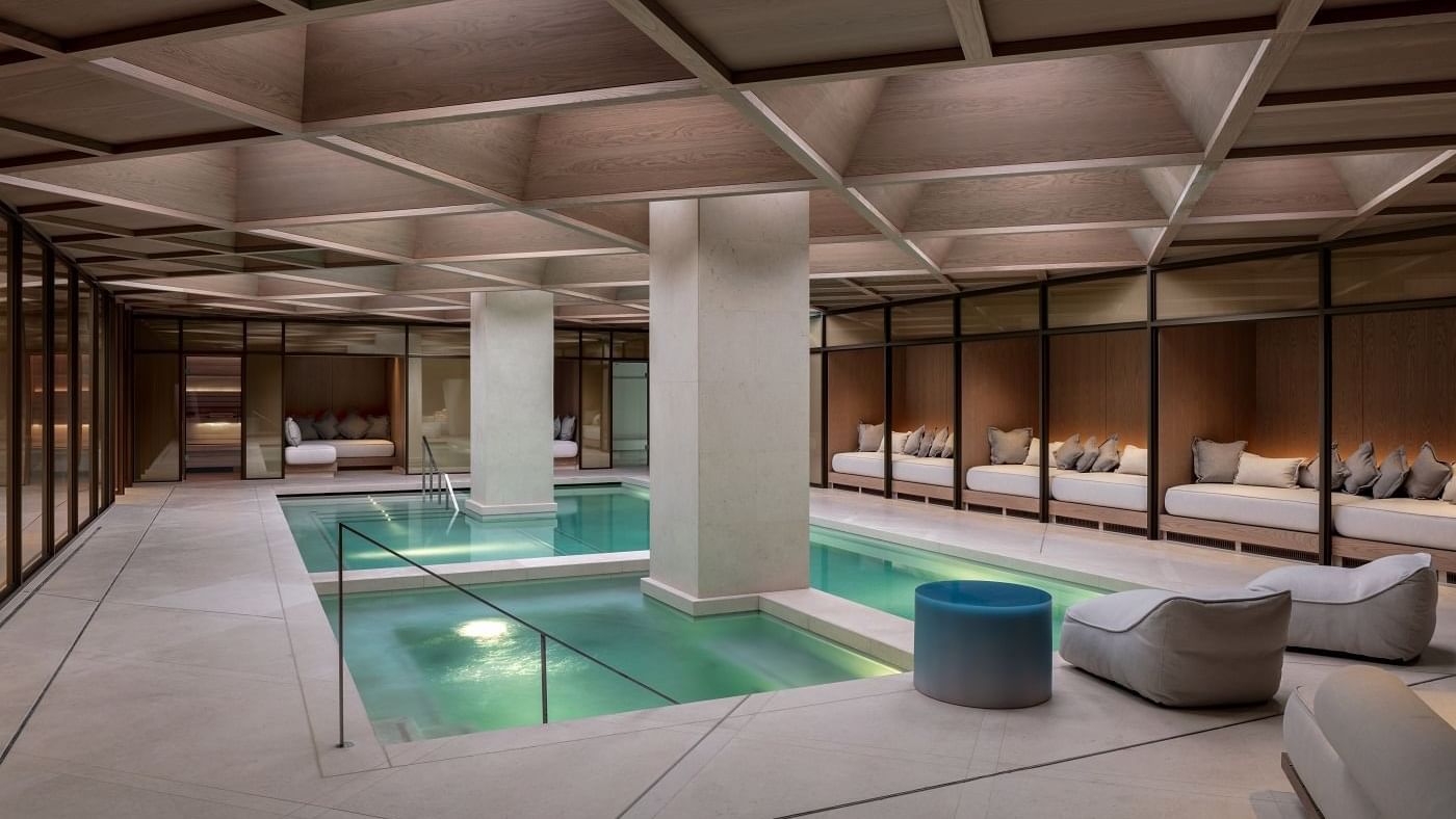 Indoor swimming pool area with pool beds at The Londoner