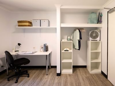 Spacious room with desk, shelf, fan, and wardrobe at UniLodge at Curtin University - Erica Underwood House.