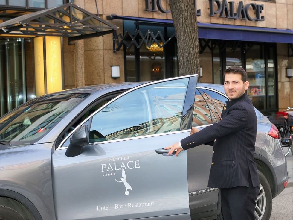 A concierge opening a car door at Hotel Palace Munich