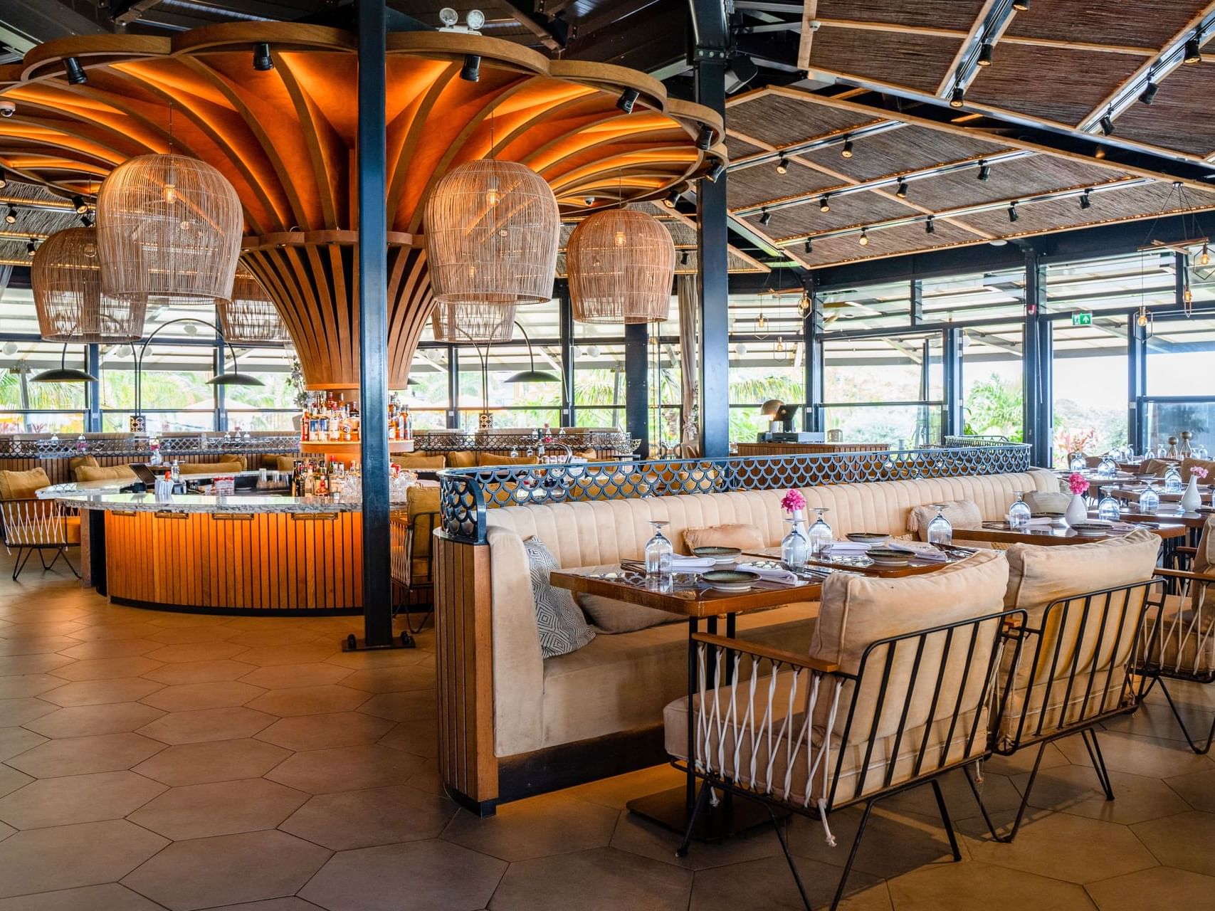 Interior of Breeze Restaurant with a central bar, plush seating, and warm lighting at Golden Rock Resort