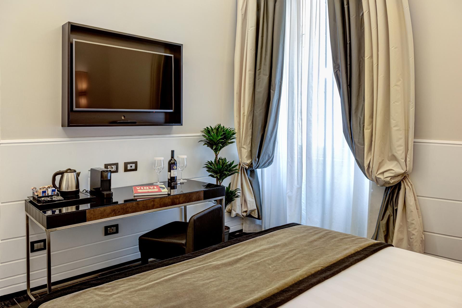 Stylish Smart Room at The Independent Suites with a desk, wall-mounted TV, and cozy ambiance filled with natural light