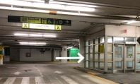Underground parking garage with glass booth beside driving lane and white arrow pointing right at Hotel X Toronto venue