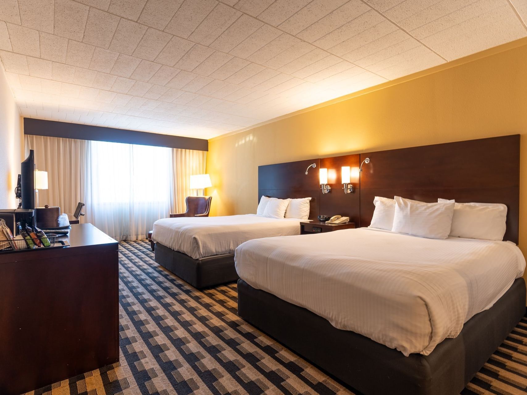 Two queen beds with headboards in a Classic Two Queen Bed Room at M Hotel Buffalo.
