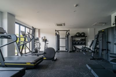 Exercise equipment's with lush greenery view through the large windows in gym at The Hub Acunmeyda