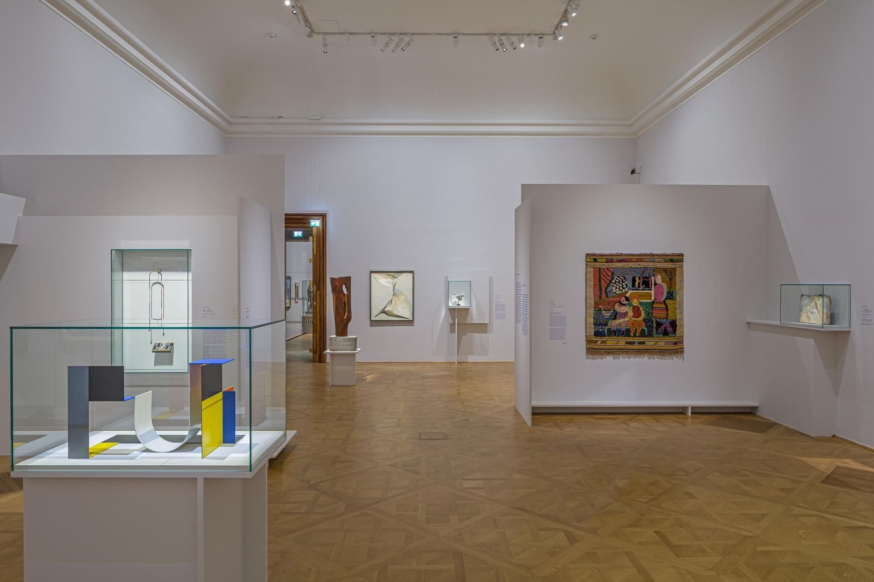 Art exhibition at the Belvedere in Vienna featuring modern sculptures, abstract artworks, a tapestry and glass display cases