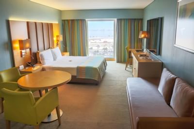 Workspace and couch by the bed in Deluxe Room at Hotel Presidente Luanda