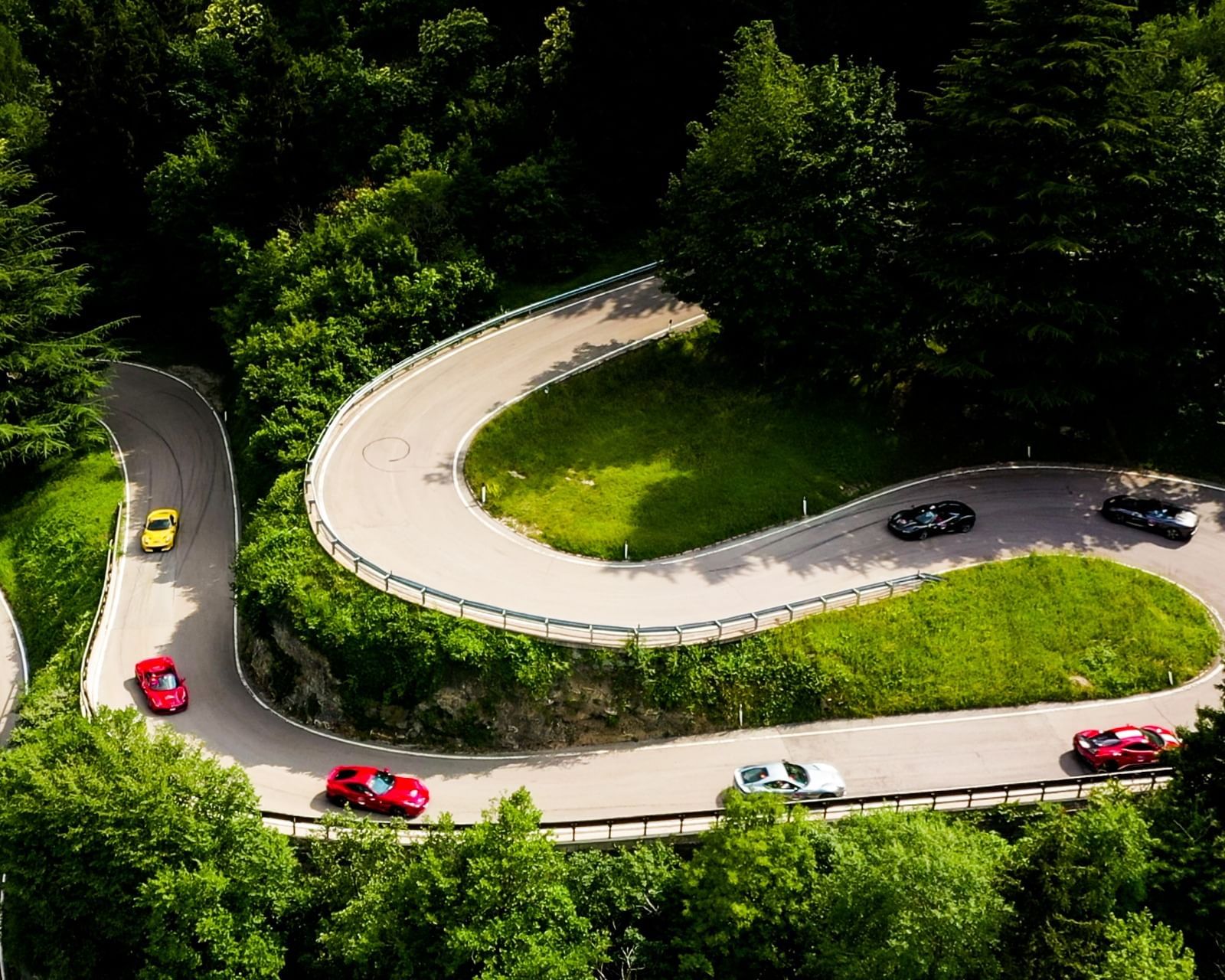 Winding Road with Luxury Cars 