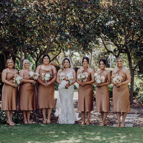 Bride taking photos with brides mates in the garden at Pullman Magenta Shores