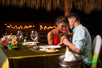 A couple at a romantic dinner with drinks at Fiesta Resort