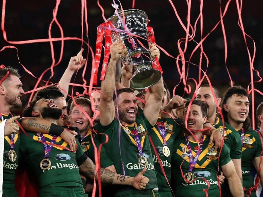 Rugby team in green jerseys celebrating with trophy amid red streamers during Rugby League World Cup 2026