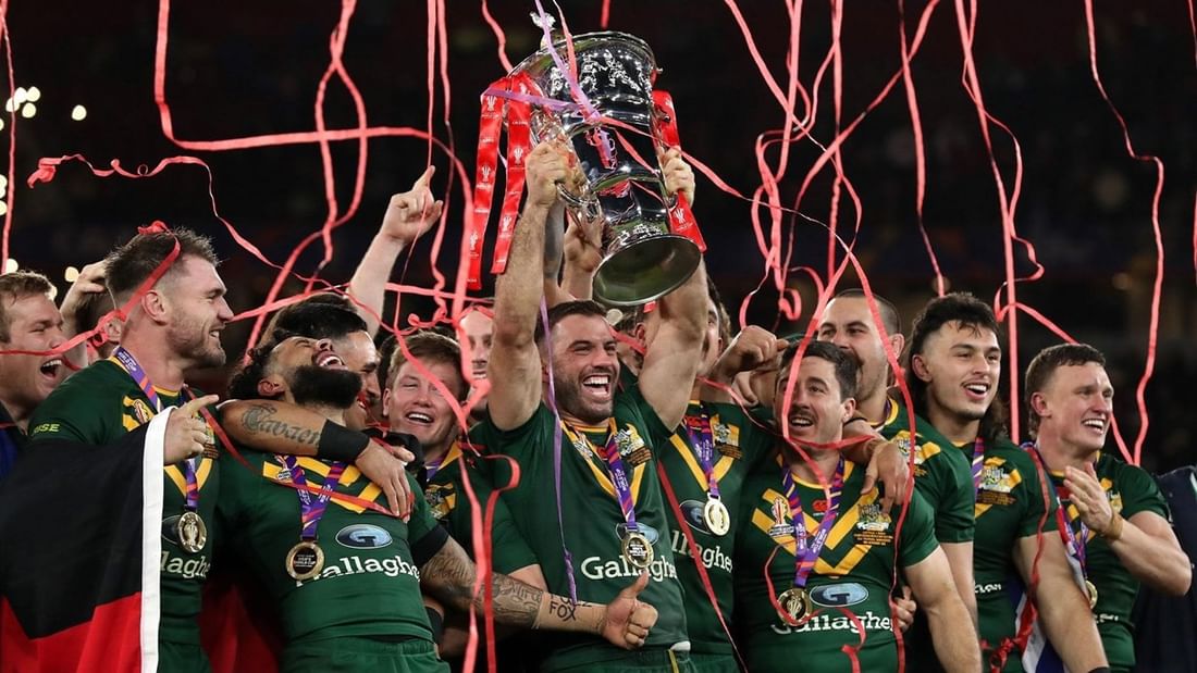 Rugby team in green jerseys celebrating with trophy amid red streamers during Rugby League World Cup 2026