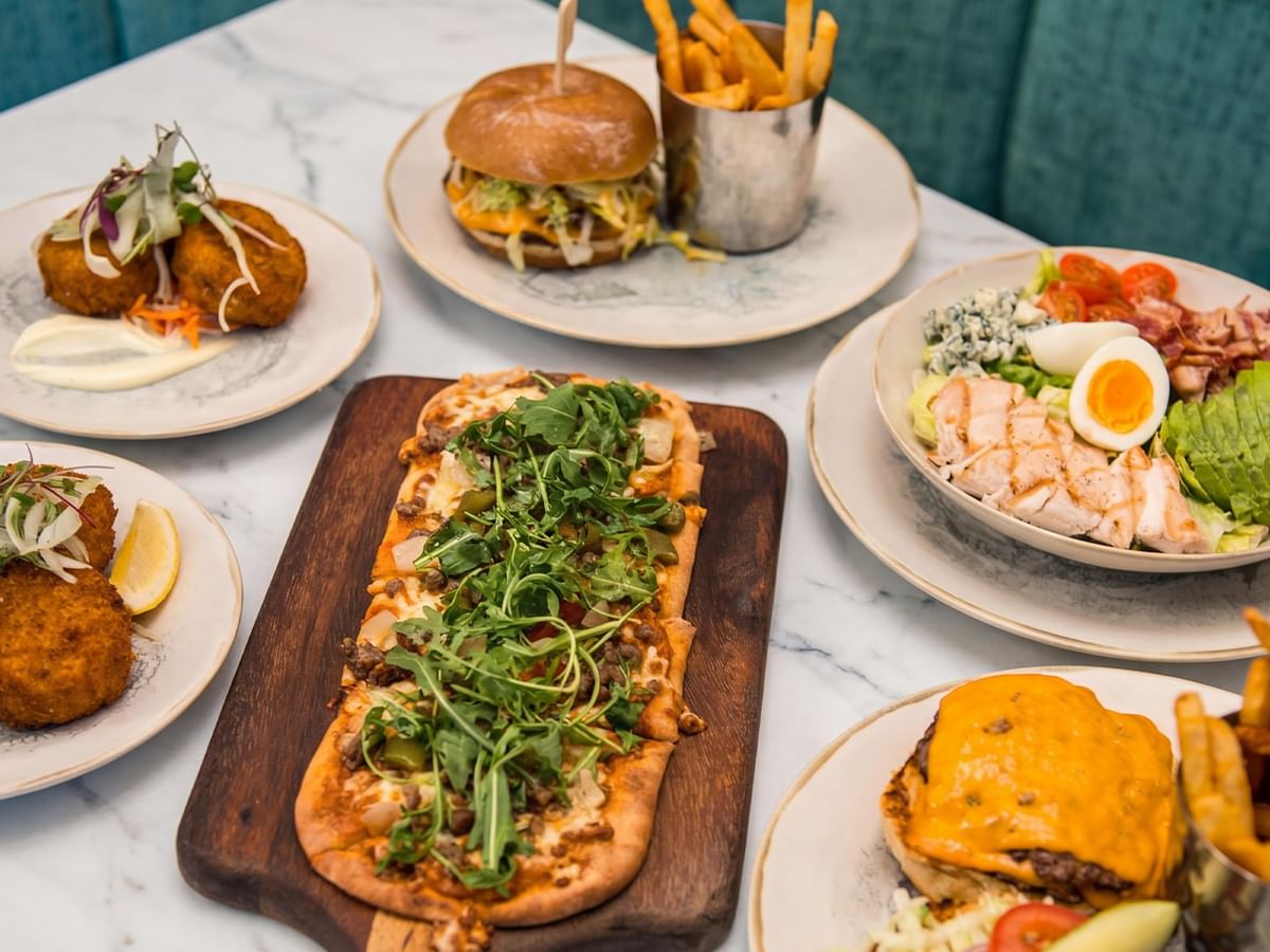 Various dishes including burgers, fries, and salads.