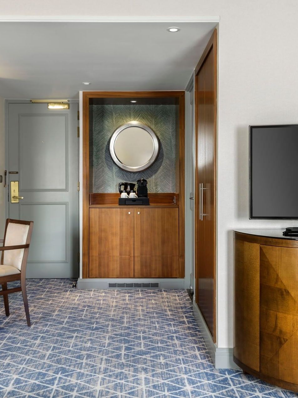 Workspace with a chair placed by a wooden cabinet in the Premium Deluxe Room at Warwick Grand Place Brussels