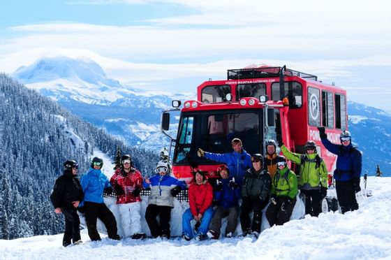 Group of people posing for a photo on snow slope during the Cat-Skiing Tours near Blackcomb Springs Suites