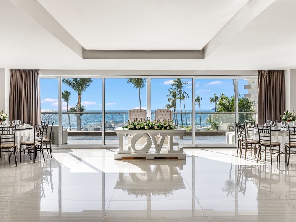 Elegant wedding reception hall with ocean views and a decorative 