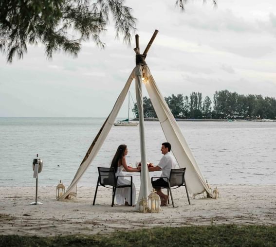 Couple enjoying dinner by the Beach on a gloomy day at The Danna Langkawi