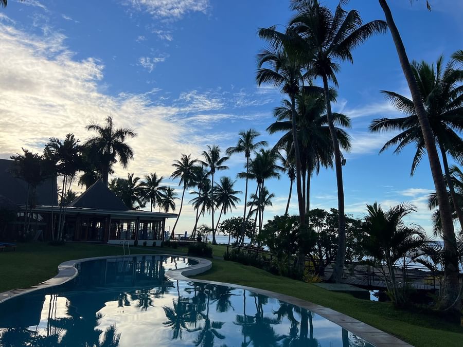 Pool with palm trees and ocean view at Tambua Sands Beach Resort - Fiji.