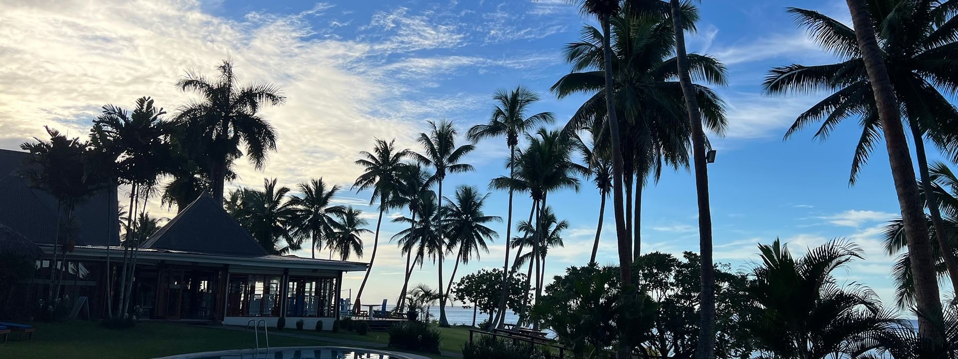 Resort pool with ocean view and palm trees at Tambua Sands Beach Resort in Sigatoka