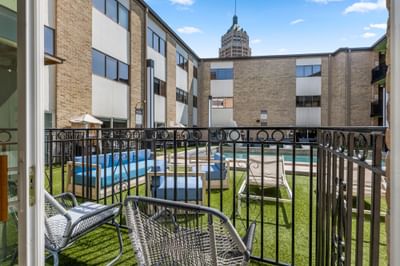 Patio view at The Riverwalk Plaza Hotel with modern seating, a pool on a sunny day under a clear blue sky
