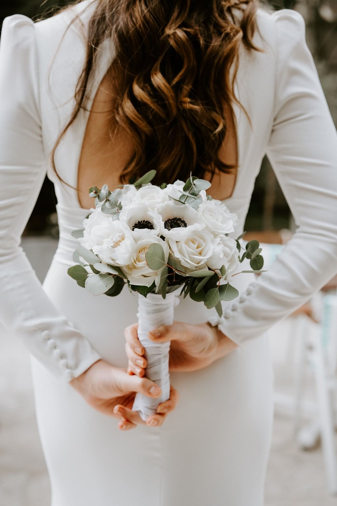 Bride holding a white rose and anemone bouquet for a wedding at Hotel Barsey by Warwick