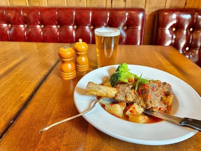 Lamb shank and beer on restaurant table