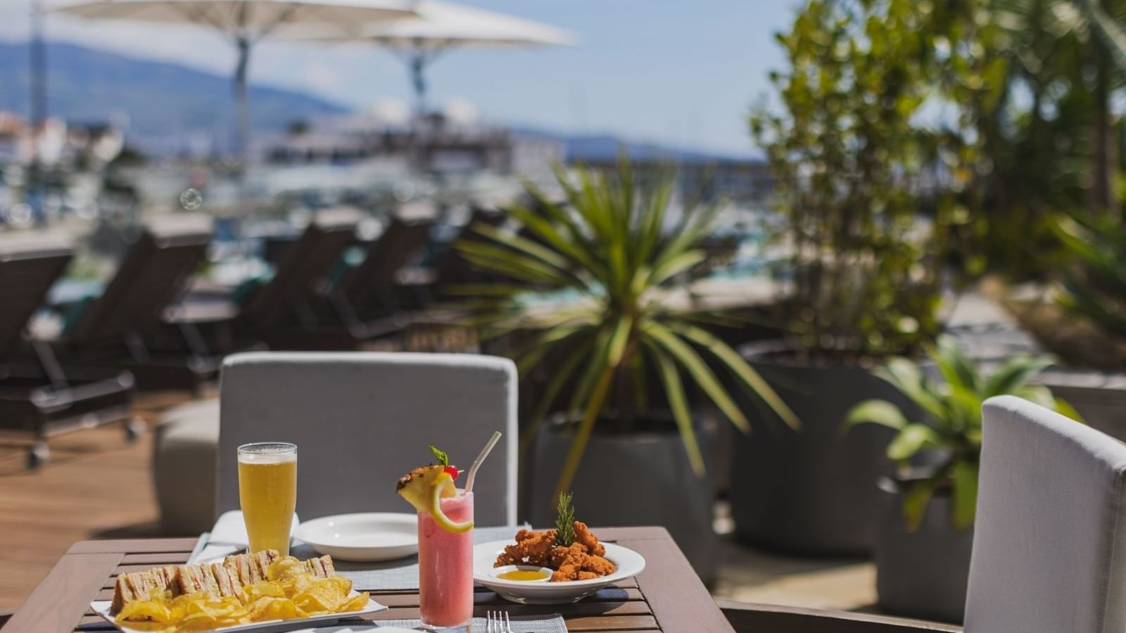 Close-up of cocktails served with sandwiches on a table in Palhabote Bar at Hotel Marina Atlântico