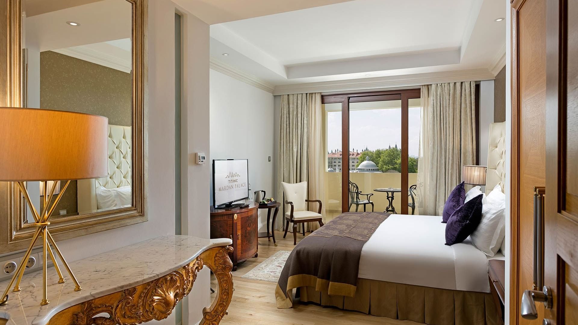 Удобная кровать и балкон в президентском люксе отеля Titanic Mardan Palace