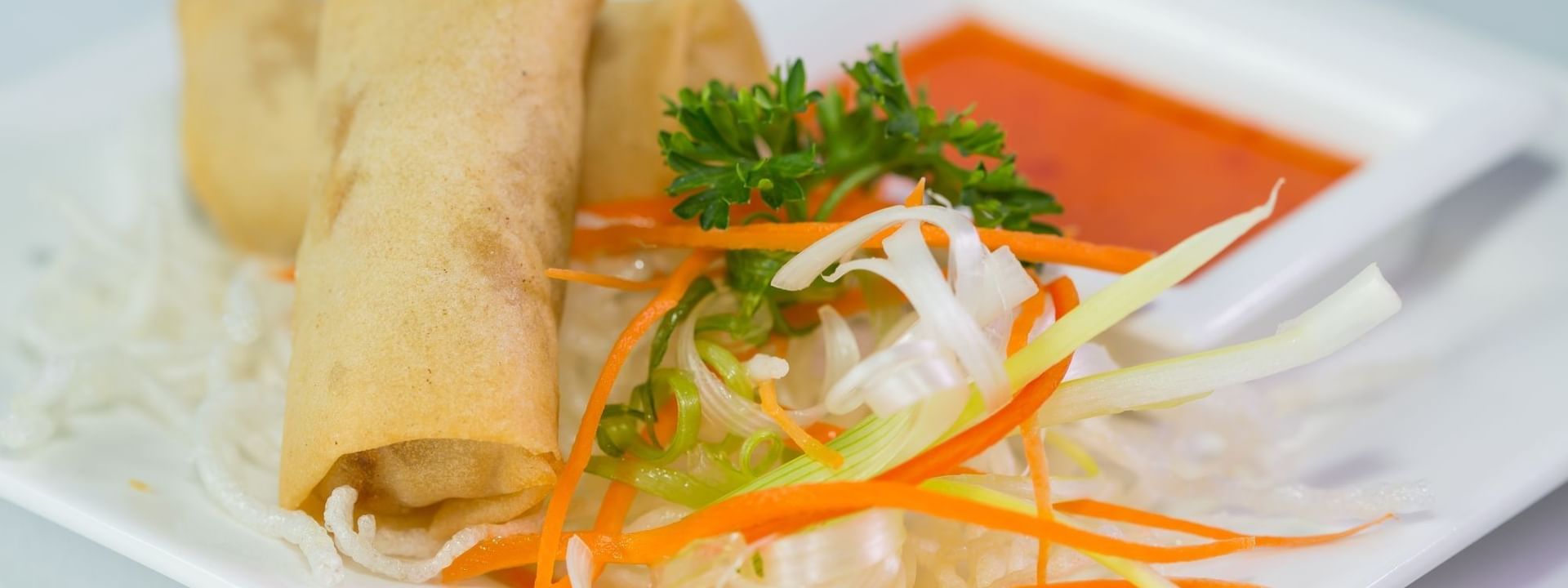 Golden spring rolls with shredded carrots and chili sauce under a in Tings on a Stick at Warwick Paradise Island Bahamas
