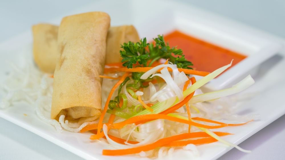 Golden spring rolls with shredded carrots and chili sauce under a in Tings on a Stick at Warwick Paradise Island Bahamas