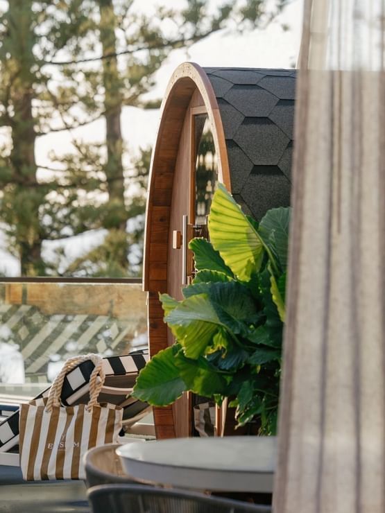 Wellness Two Bedroom Suite at Elysium Manly by tropical leaves under a shingled roof near a striped lounger & canvas tote bag