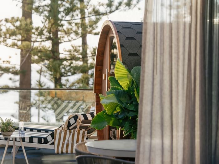 Wellness Two Bedroom Suite at Elysium Manly by tropical leaves under a shingled roof near a striped lounger & canvas tote bag