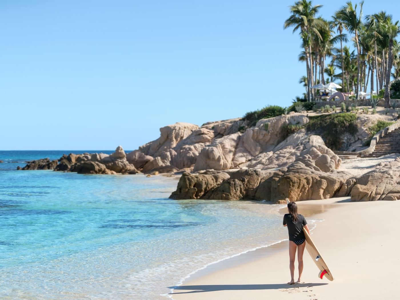 A girl ready to surfing Cabo beach near Grand Fiesta Americana