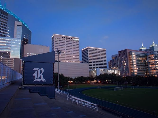 Twilight city skyline view near Granduca Houston, featuring Texas Medical Center and a nearby sports field