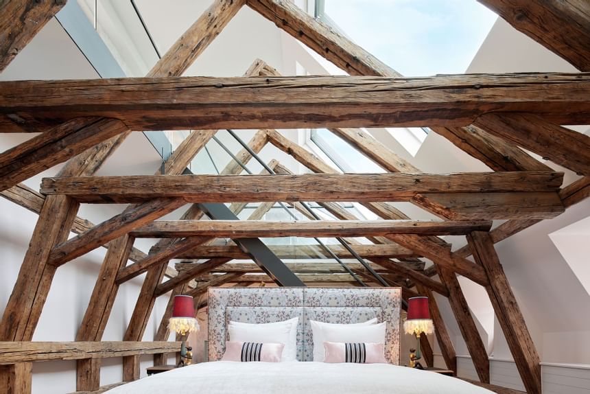 Old wooden beams support the roof with skylights through which the light falls into the room in the hotel in Vienna