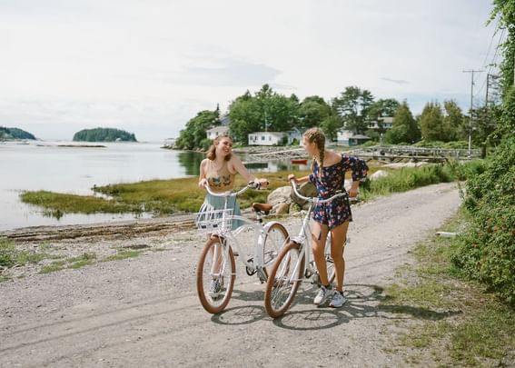 Ladies posing with bicycles on a street by the sea near Sebasco Harbor Resort