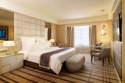 TV stand & work desk facing a bed in Executive Deluxe with carpeted floors, A One World Hotel room
