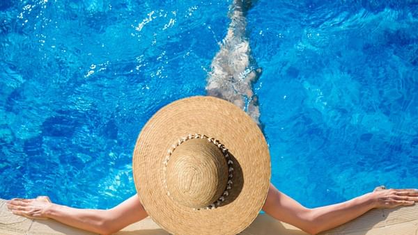 Woman in a hat relaxing in pool at Warwick Doha