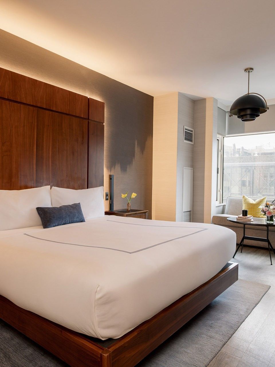 Deluxe Room with king bed, wood headboard, city views, and modern seating at Gansevoort Meatpacking NYC - NEW