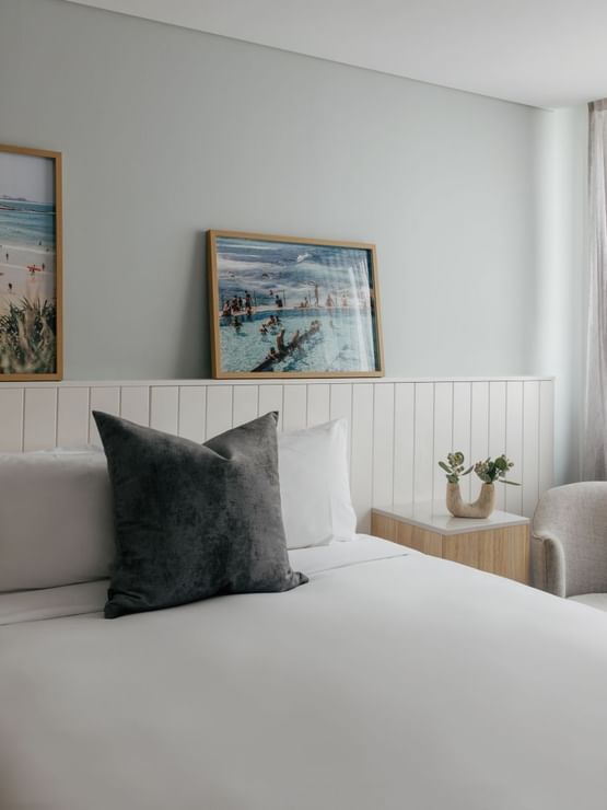 Village Queen at Elysium Manly, featuring a grey cushion on a bed by an armchair, one of the best places to stay in Manly
