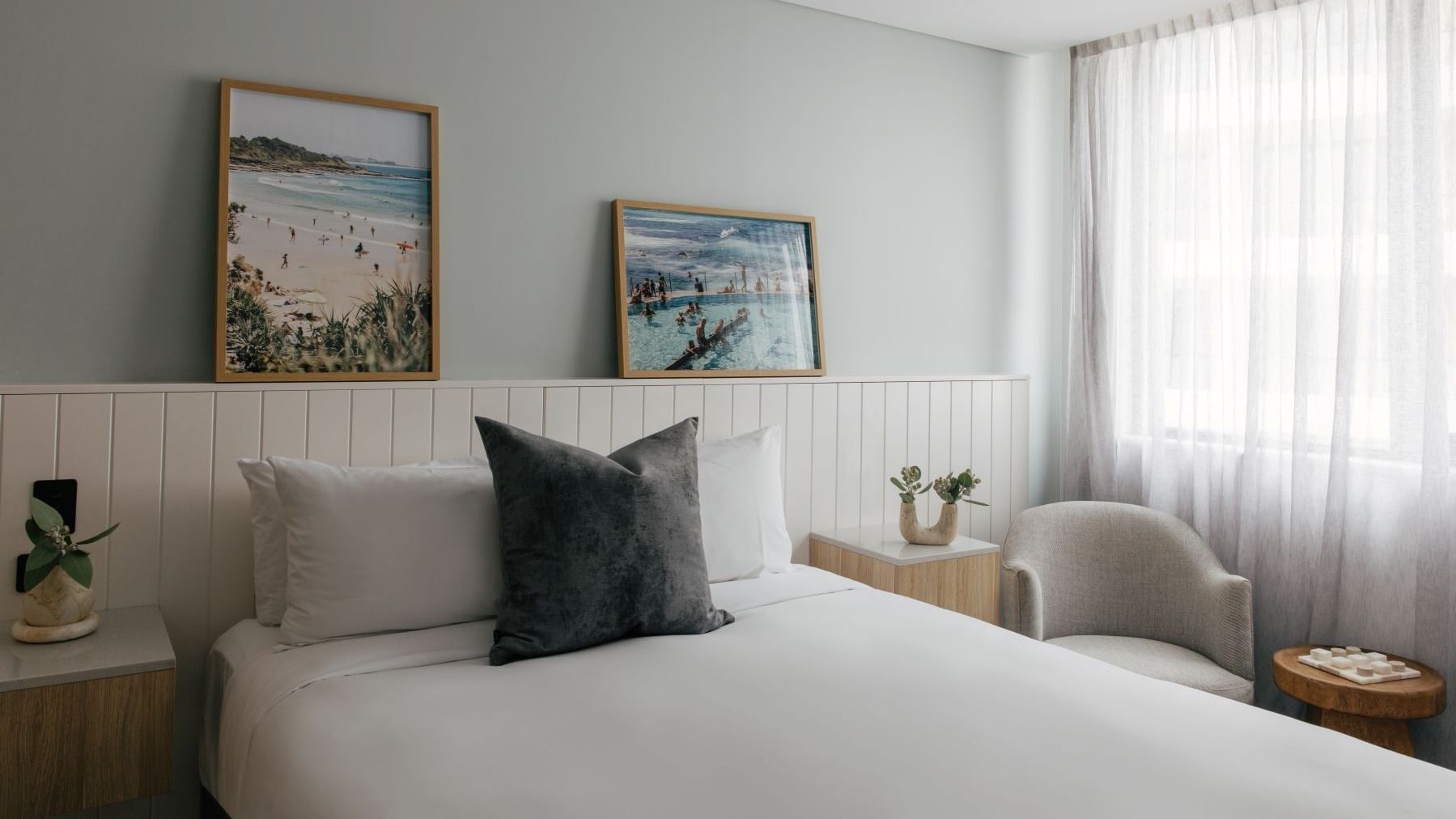 Village Queen at Elysium Manly, featuring a grey cushion on a bed by an armchair, one of the best places to stay in Manly