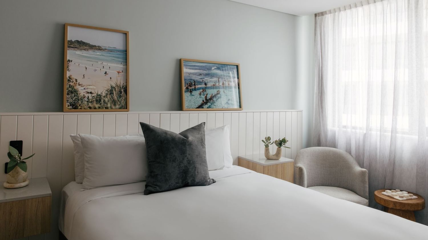 Village Queen at Elysium Manly, featuring a grey cushion on a bed by an armchair, one of the best places to stay in Manly
