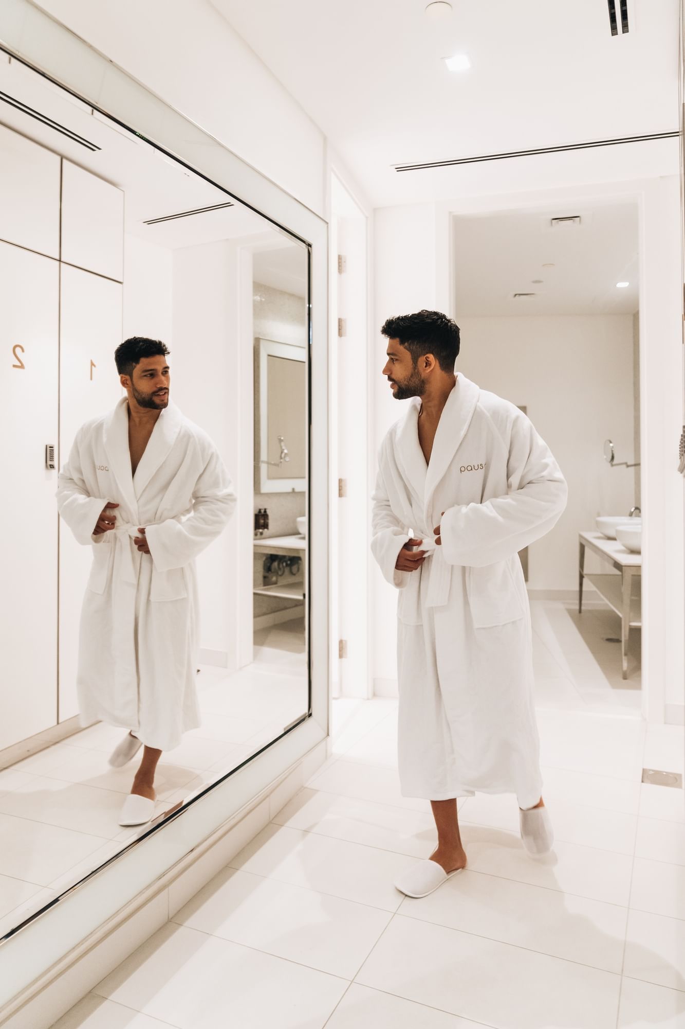 Man in robe posing by a mirror in Pause Spa at Paramount Hotel Dubai