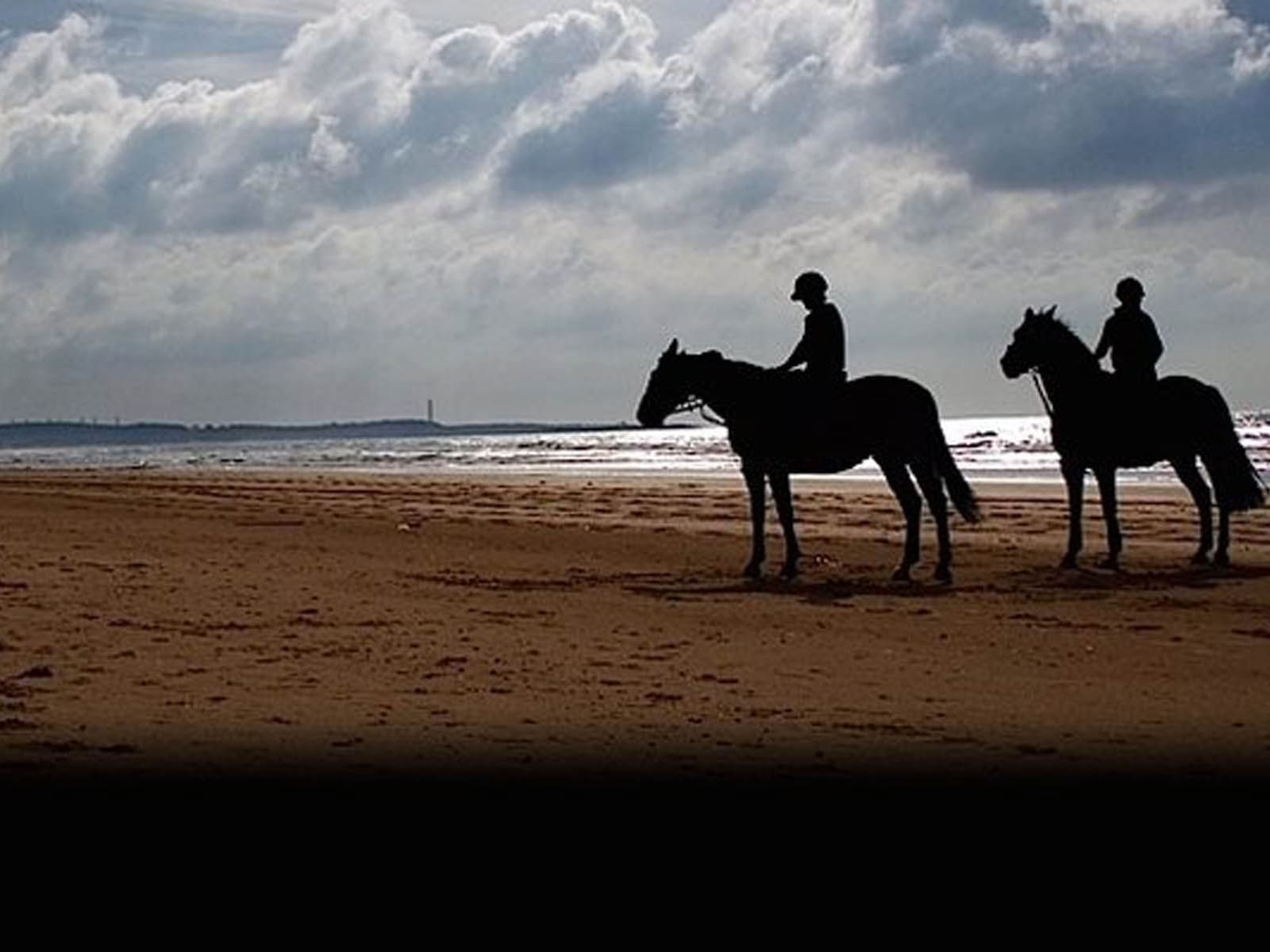 Two people riding horses on a beach near Hotel Cascais Miragem Health & Spa