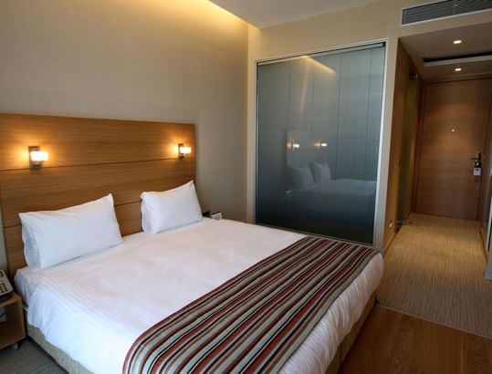 Apart Room with a double bed, side lamps and wooden accents at Titanic Anadolu Gebze